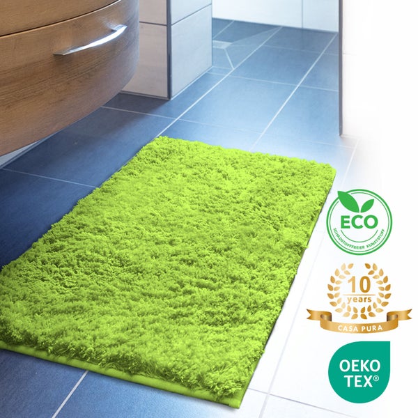 Grüne Badematte vor einem Badezimmerschrank mit dem Eco Siegel, dem Casa Pura Siegel und dem Oeko-Tex Siegel