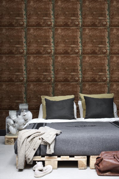Schlafzimmer mit Bett vor Wandtapete im Industriedesign