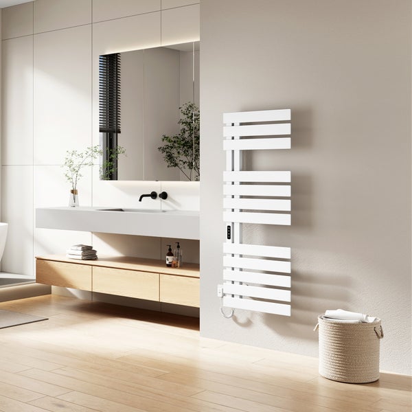 Moderner, weißer elektrischer Badheizkörper mit asymmetrischen Sprossen, montiert an einer Wand in einem hellen, minimalistischen Badezimmer.