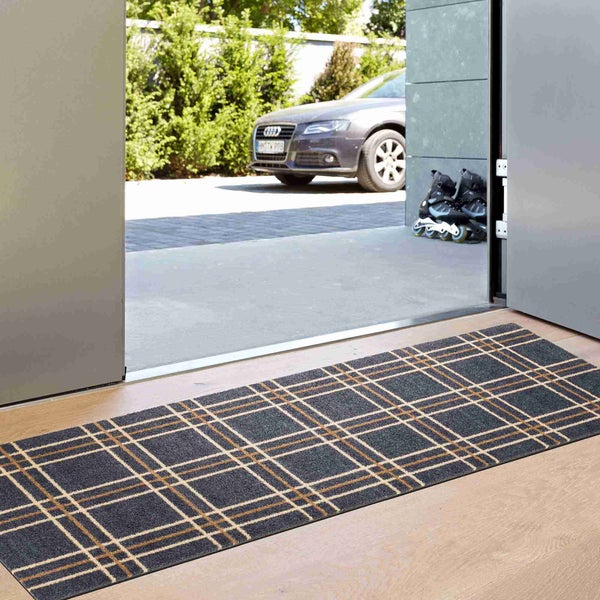 Fußmatte mit Karomuster vor einer Haustür