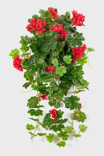 Detailaufnahme einer künstlichen Geranie mit grünen Blättern und roten Blüten.