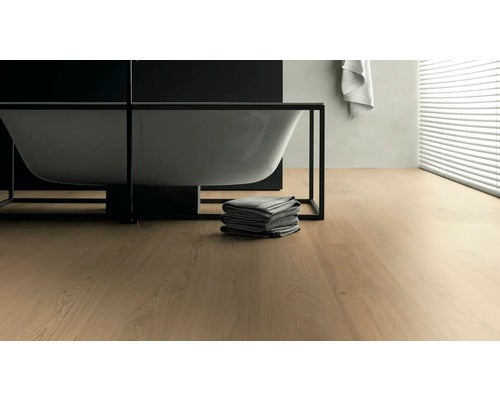 Badezimmer mit Badewanne, Handtüchern und hellem Holzboden