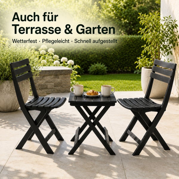 Gartenbistroset bestehend aus zwei klappbaren Stühlen und einem kleinen Tisch auf einer Terrasse vor einer Gartenkulisse.