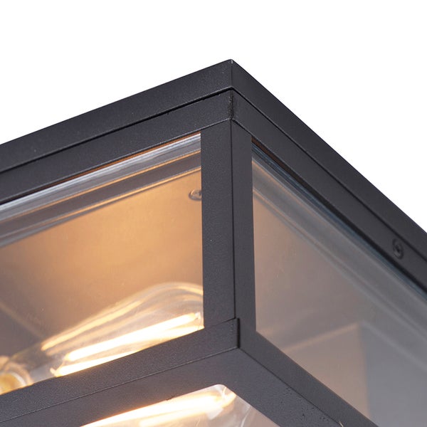 Nahaufnahme einer Ecke einer schwarzen Außenleuchte aus Metall mit Klarglas und leuchtenden Filamentlampen.