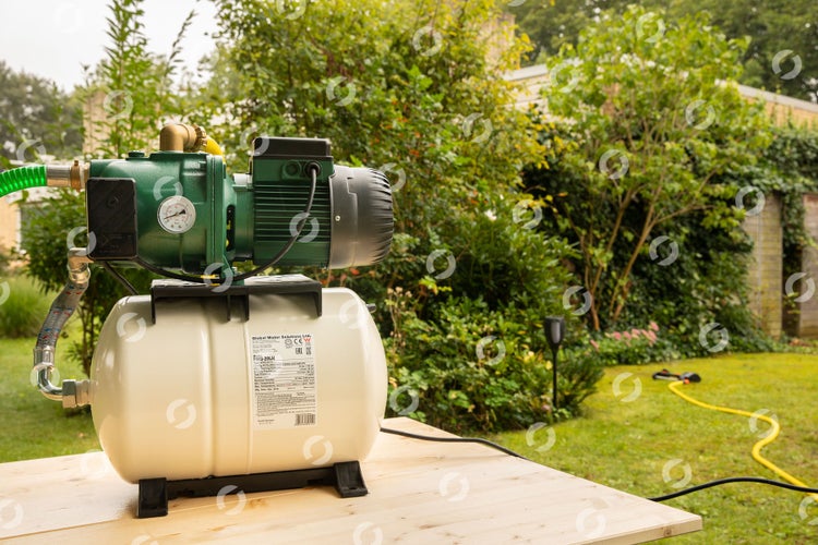 Hauswasserwerk auf Holztisch im Garten