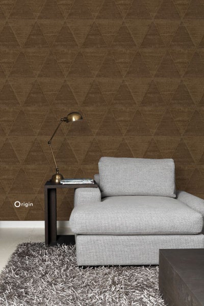 Wohnzimmer mit brauner Tapete mit Dreiecksmuster, Sessel, Tisch und Lampe