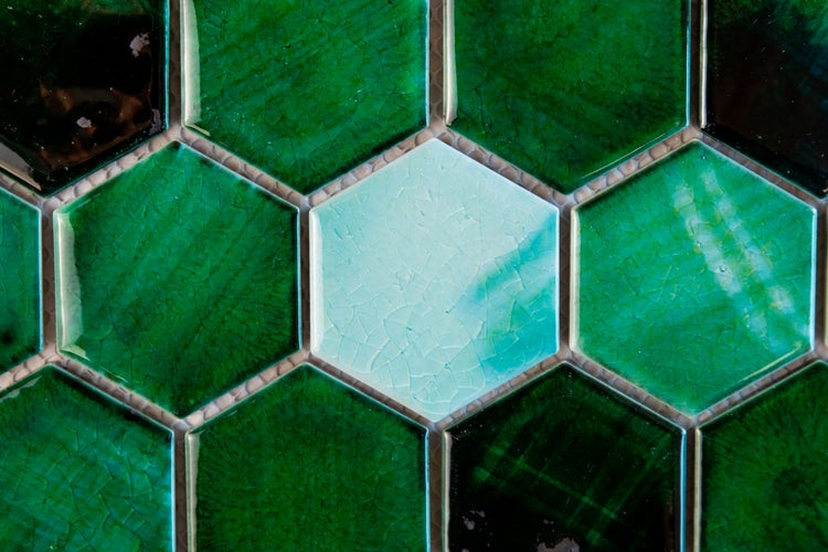 Sechseckige Fliesen in Grün und einer hellen Farbe