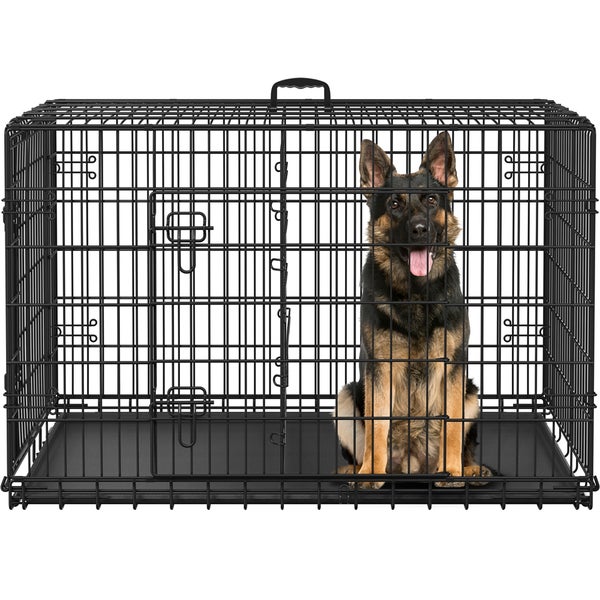 Schäferhund sitzt in einer schwarzen Drahttransportbox für Hunde.