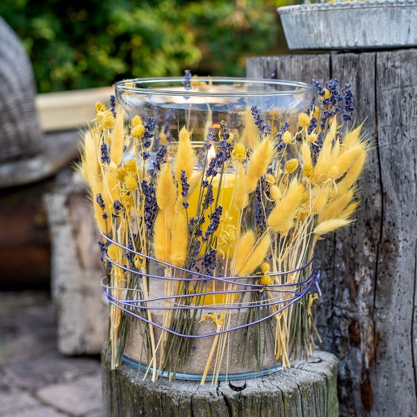 Schwarzer Pflanzkasten mit Rankgitter im Blätterdesign, bepflanzt mit bunten Blumen und Kletterpflanzen.