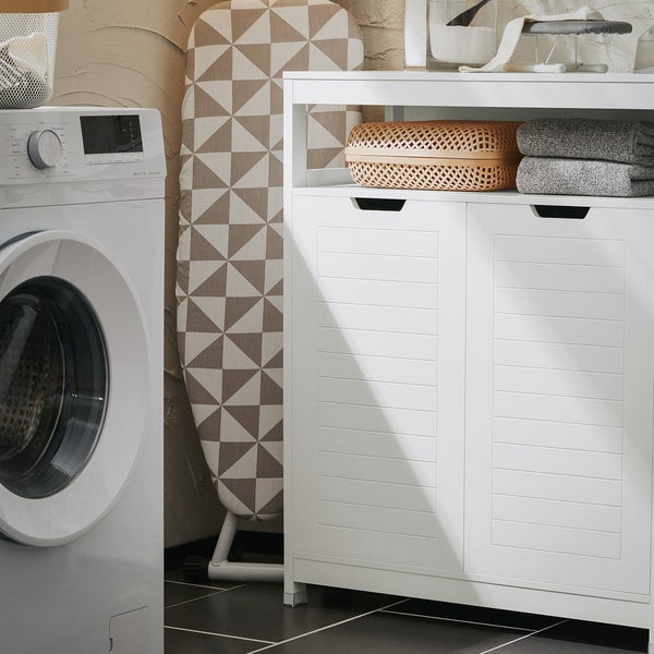 Waschküchenszene mit Waschmaschine, Bügelbrett und weißem Badezimmerschrank