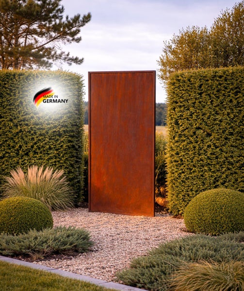Rechteckiger Sichtschutz aus Cortenstahl stehend im Garten zwischen Hecken mit Made in Germany Siegel