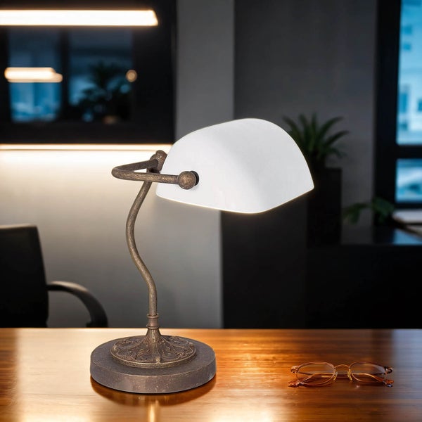 Tischleuchte mit Lampenschirm auf einem Schreibtisch mit Brille