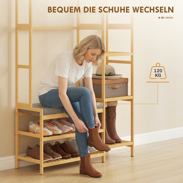 Eine Frau sitzt auf einem Schuhregal aus Holz mit gepolsterter Sitzfläche und zieht Stiefel an. Maximale Belastbarkeit 120 Kilogramm.