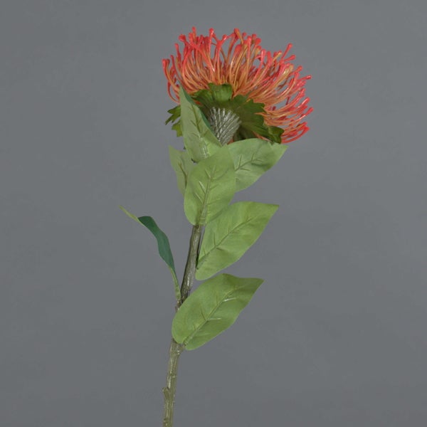 Künstliche Protea mit orangefarbener Blüte, grünen Blättern und Stiel.