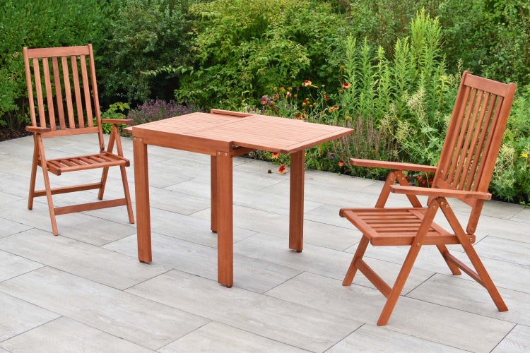 Gartenszene mit Holztisch und zwei Holzstühlen auf einer Terrasse