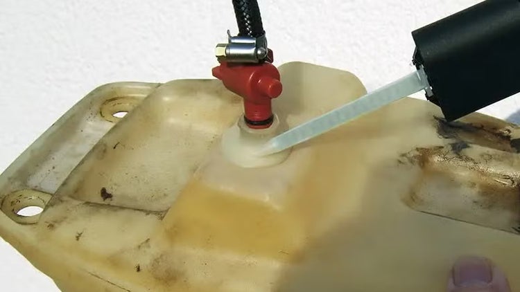 Reparatur eines undichten Kunststofftanks mit einem Reparaturset und einer Klebepistole