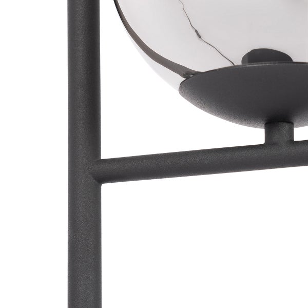 Detailaufnahme einer Stehlampe mit Metallgestell und Glasschirm