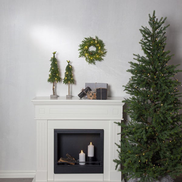 Weihnachtliche Wohnraumdekoration mit Kamin, Baum, Kranz und Geschenken