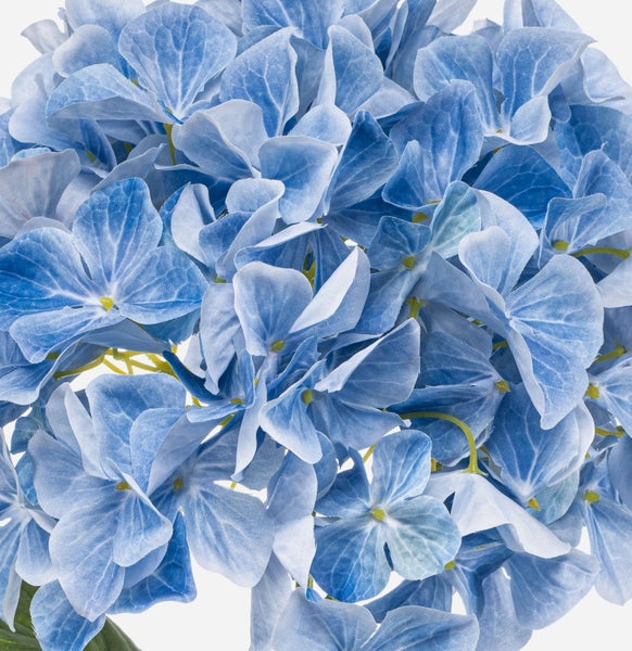 Künstliche Hortensie mit blauen Blüten und grünen Blättern.