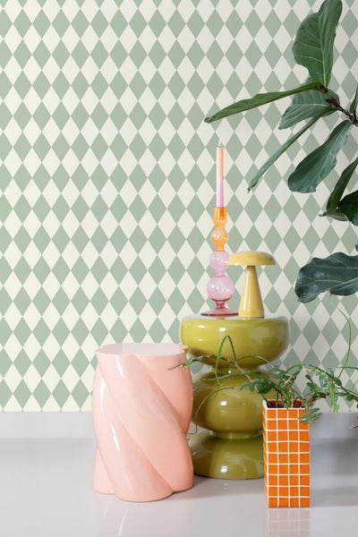 Szene mit Tapete mit Rautenmuster, einem Beistelltisch, Dekorationsgegenständen und einer Zimmerpflanze