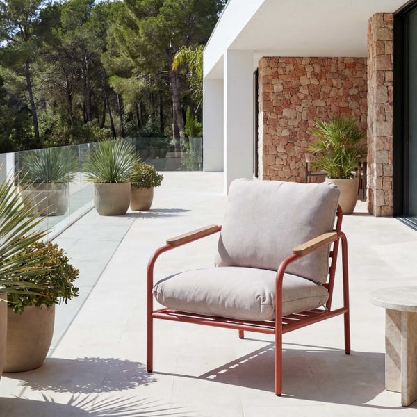 Moderner Loungesessel für den Außenbereich mit Metallgestell, Holzarmlehnen und hellgrauen Kissen auf einer sonnigen Terrasse.