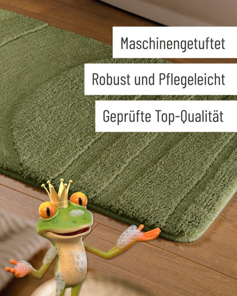 Grüne Badematte mit Wellenstruktur auf Holzfußboden neben einer Badewanne.