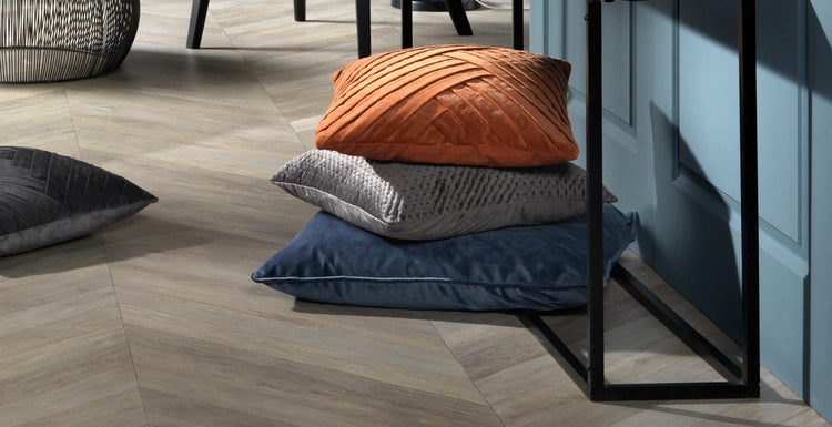 Stapel dekorativer Kissen auf einem Holzboden