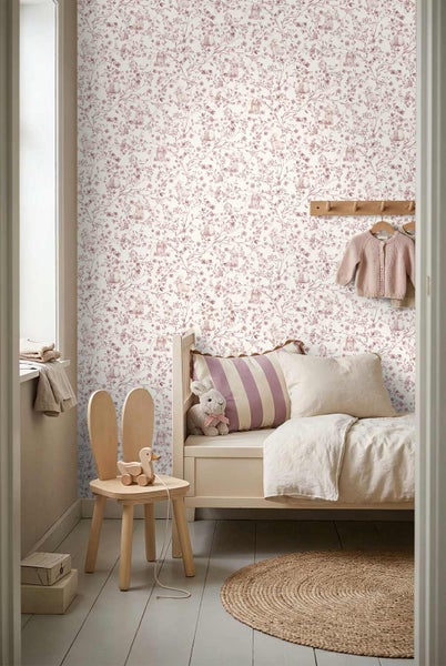 Vliestapete mit floralem Muster und Hasenmotiven in einem hellen Kinderzimmer mit Holzbett, Hasenstuhl und rundem Juteteppich.