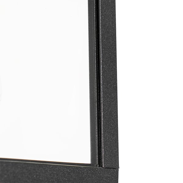 Detailaufnahme eines schwarzen Metallrahmens mit Glaseinsatz und strukturierter Oberfläche.