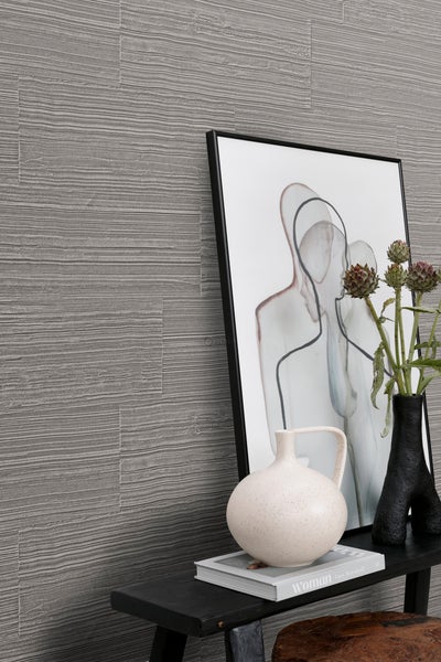 Nahaufnahme von Wandpaneelen mit horizontaler Maserung, kombiniert mit einem gerahmten Bild, Vasen und dekorativen Elementen auf einem Tisch