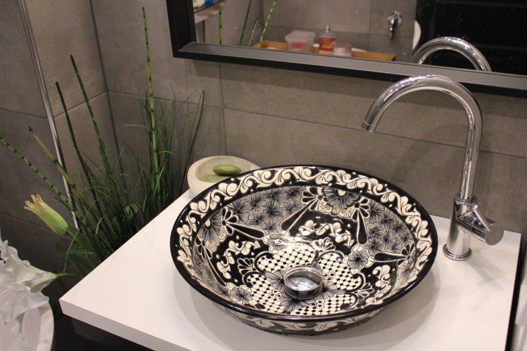 Waschbecken mit floralem Muster und Armatur auf einem Waschtisch