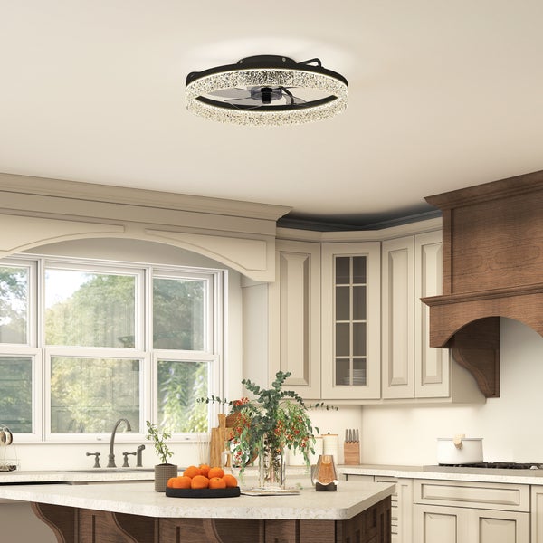 Moderner Deckenventilator mit integriertem Lichtring in einer hellen Küche über einer Kücheninsel mit Obst und Pflanzen.