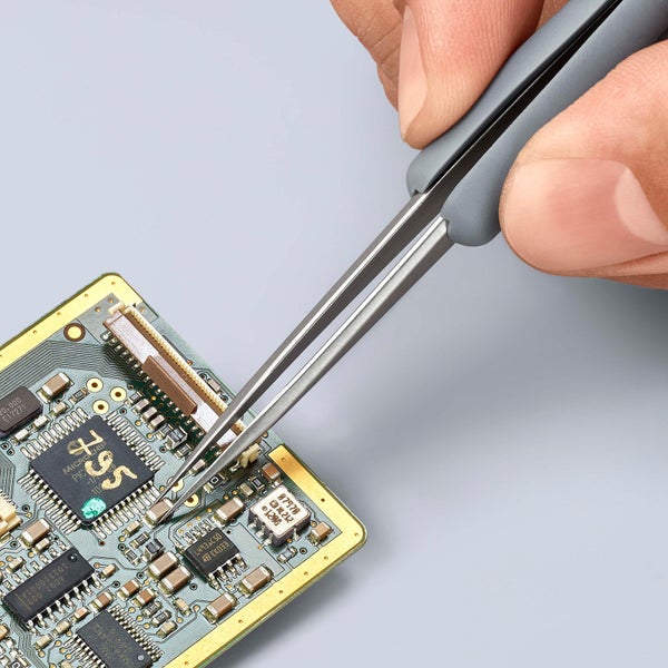 Elektronikpinzette in Verwendung auf einer Platine für Elektronikarbeiten