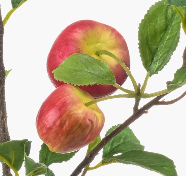 Nahaufnahme eines grünen künstlichen Pflanzenstiels mit gezackten Blättern.