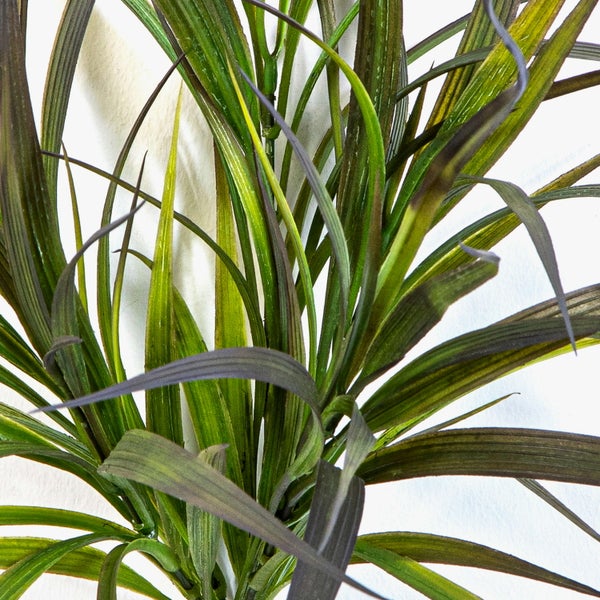 Künstliches Ziergras mit langen, schmalen grünen und dunkelvioletten Blättern.