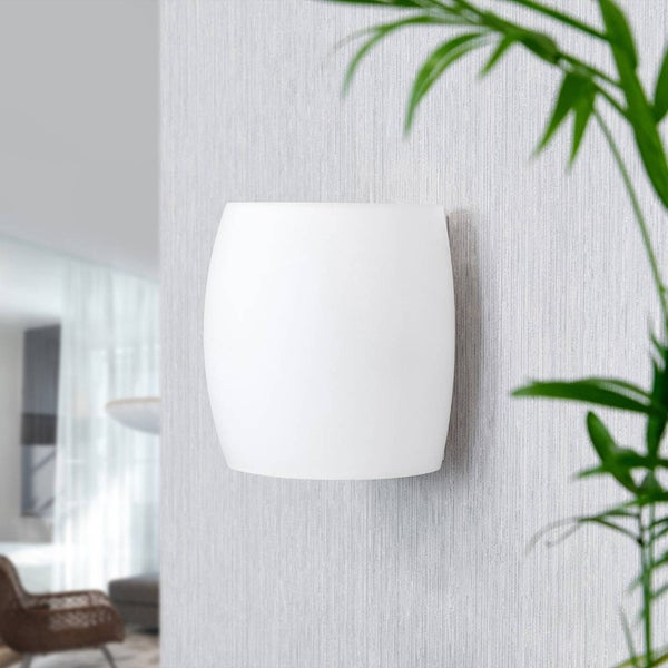 Weiße, gewölbte Wandleuchte aus Glas an einer hellgrauen strukturierten Wand in einem hellen Innenraum.