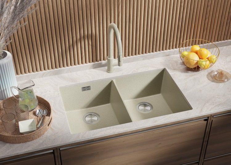 Küchenspüle aus Verbundmaterial mit zwei Becken und Armatur auf einer Arbeitsplatte mit Küchenutensilien und Dekoration