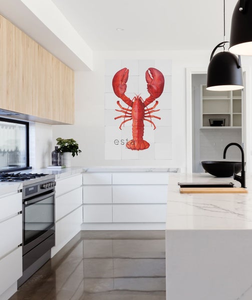 Helle Küche mit Küchenzeile, Kochfeld, Spüle und Wandbild mit Hummer-Motiv
