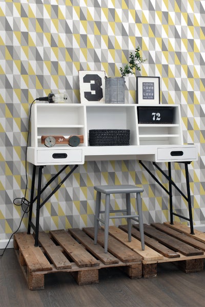 Arbeitszimmer mit weißem Schreibtisch, Regalaufsatz, grauen Hocker und Europlatten als Podest