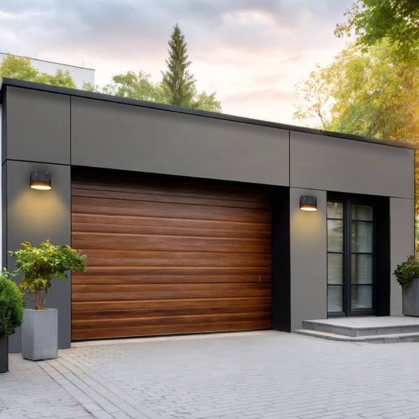 Moderne Garage mit Holztor, Außenbeleuchtung und Pflanzgefäßen