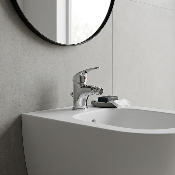 Einhebel-Bidetarmatur aus verchromtem Metall auf einem weißen Bidet in einem modern gestalteten Badezimmer.