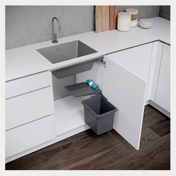 Mülltrennsystem in einem weißen Unterschrank unter einer grauen Spüle mit einer Ablage für Müllbeutel in einer hellen, modernen Küche.