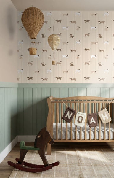 Helles Kinderzimmer mit Tapete im Hundedesign über grüner Holzvertäfelung, einem Holz-Kinderbett, Schaukelpferd und geflochtenen Heißluftballon-Dekoren.