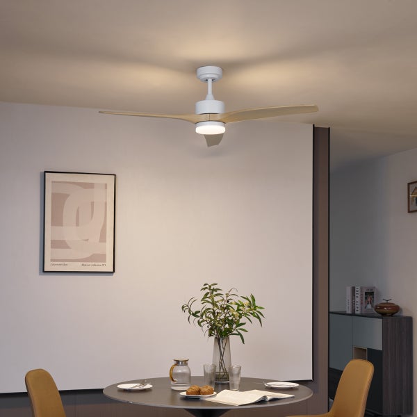 Moderner Deckenventilator mit Holzflügeln und integrierter Leuchte über einem runden Esstisch in einem hellen, minimalistischen Esszimmer.