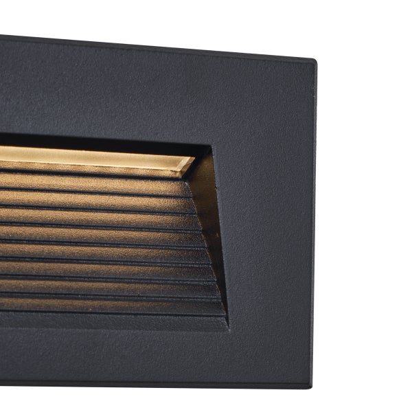 Detailansicht einer rechteckigen LED-Wandeinbauleuchte für den Außenbereich mit strukturierter Oberfläche und horizontalen Lamellen.