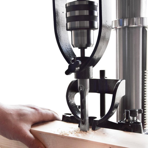 Bohrmaschine bohrt ein Loch in ein Stück Holz.