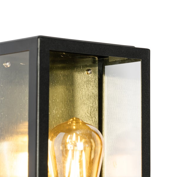 Nahaufnahme einer modernen Außenwandleuchte mit schwarzem Metallrahmen, goldfarbener Rückwand und Filament-Leuchtmittel.