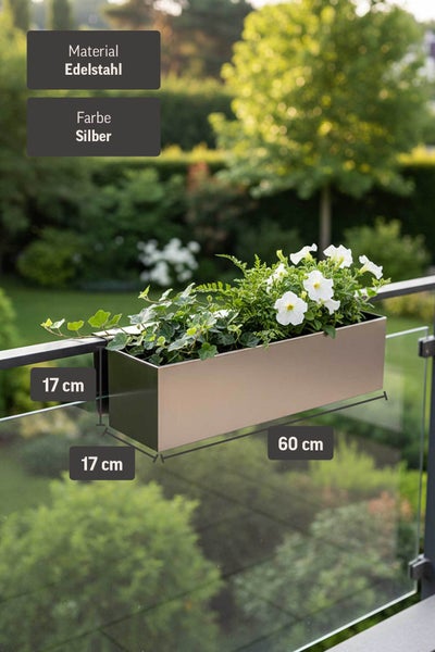Heller, moderner Balkonkasten aus Edelstahl am Geländer mit weißen Blumen. Maße 60 Zentimeter mal 17 Zentimeter mal 17 Zentimeter.