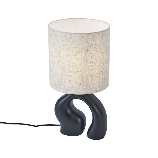 Tischleuchte mit abstraktem schwarzen Fuß und einem zylindrischen Stoffschirm in Hellgrau.