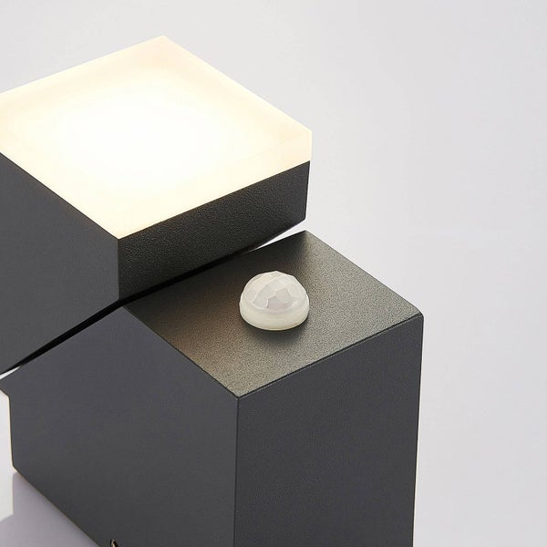 Moderne Wandleuchte in Würfelform mit Bewegungsmelder und warmweißem Licht.